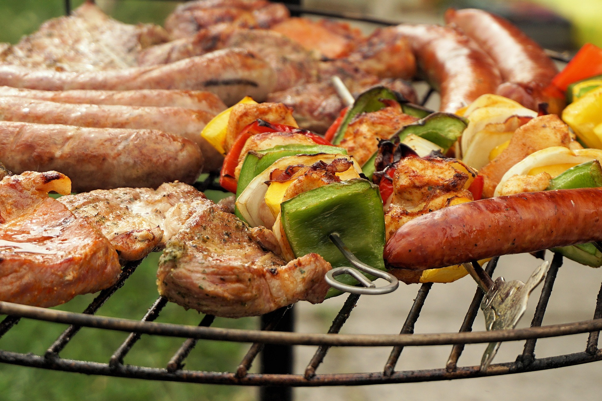Steaks, Hot Dogs, and Vegetables On a Grill